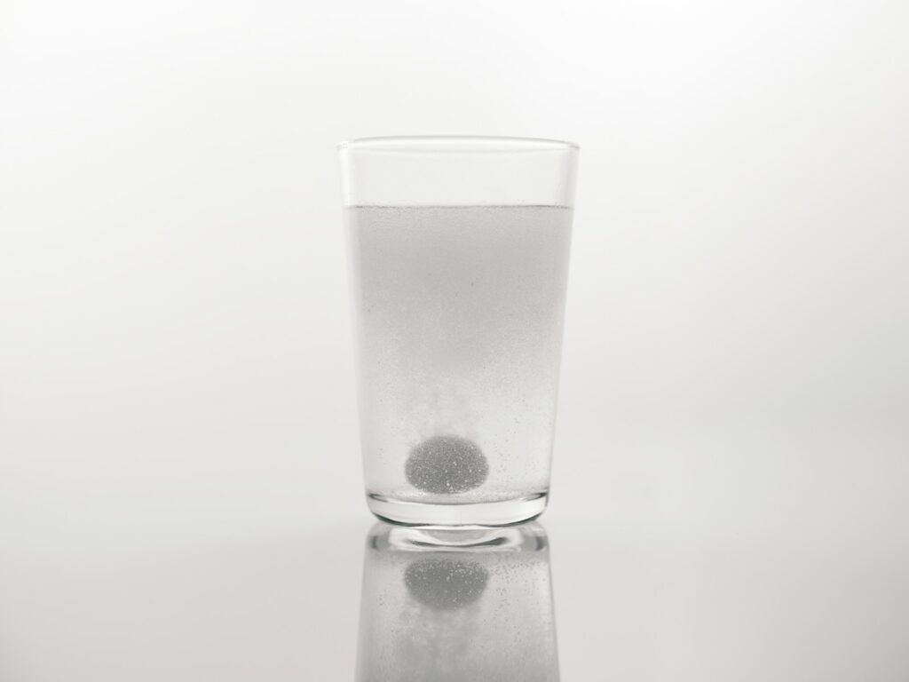 a glass of water with a black dot in it