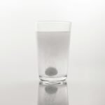 a glass of water with a black dot in it