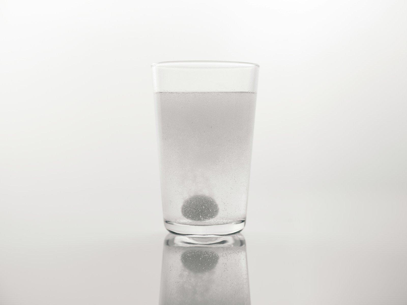 a glass of water with a black dot in it